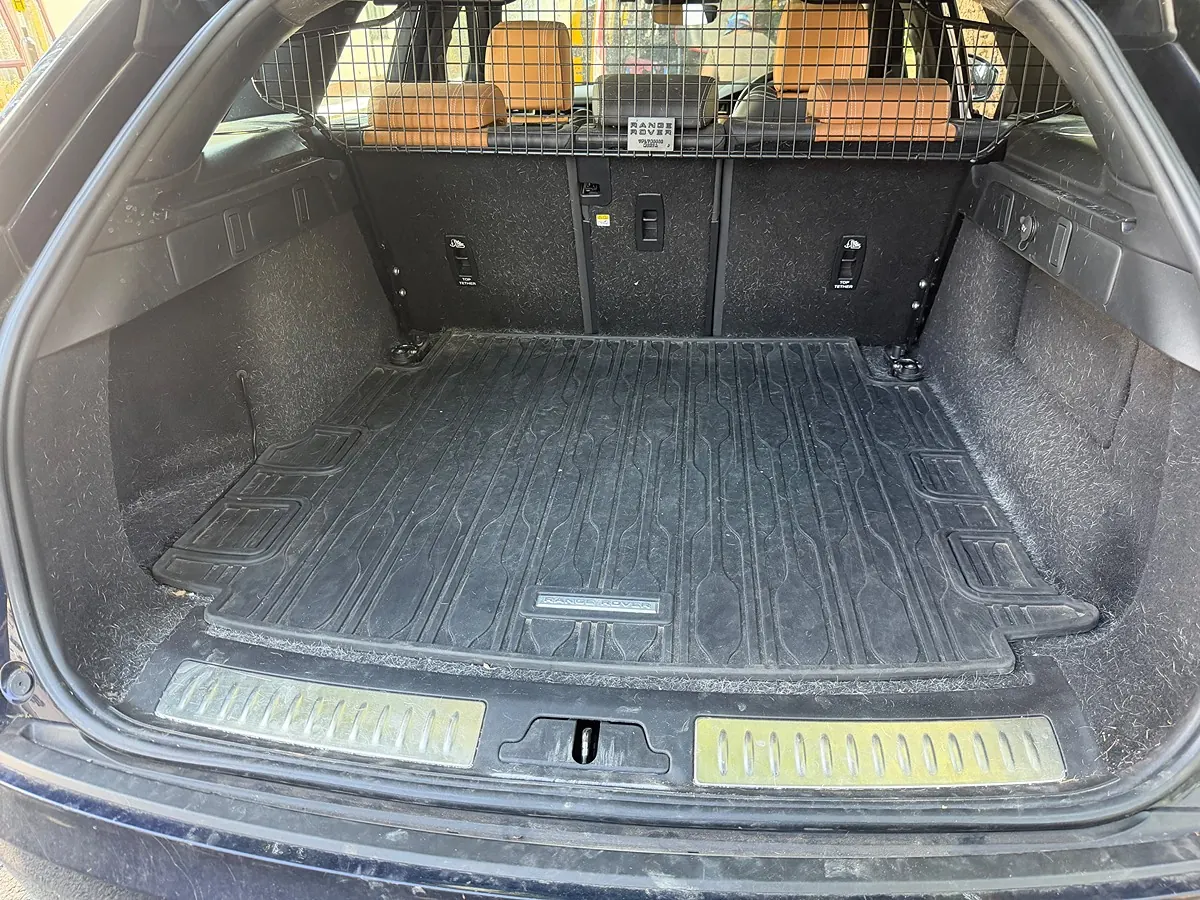 A clean SUV boot behind a dog guard, rubber liner and carpet free of hair and mud