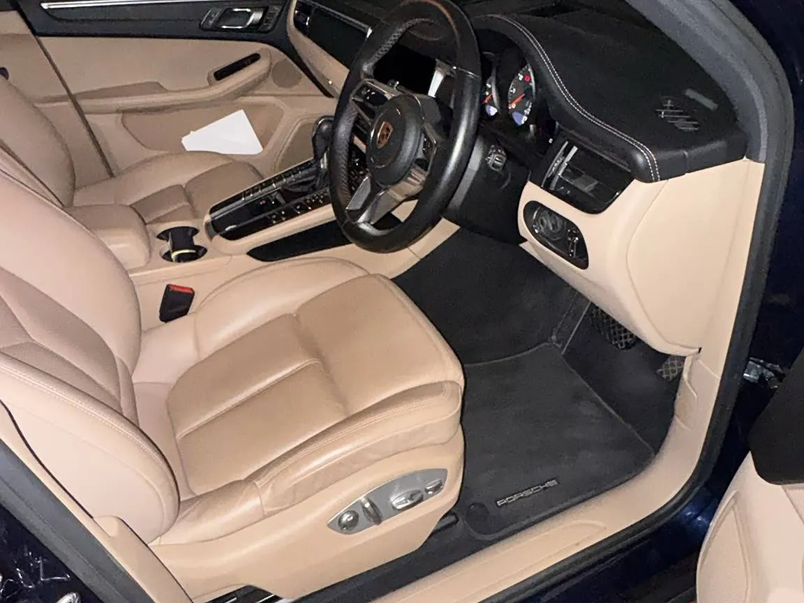 Cream leather front seats and carpets of a Porsche Macan after an interior valet