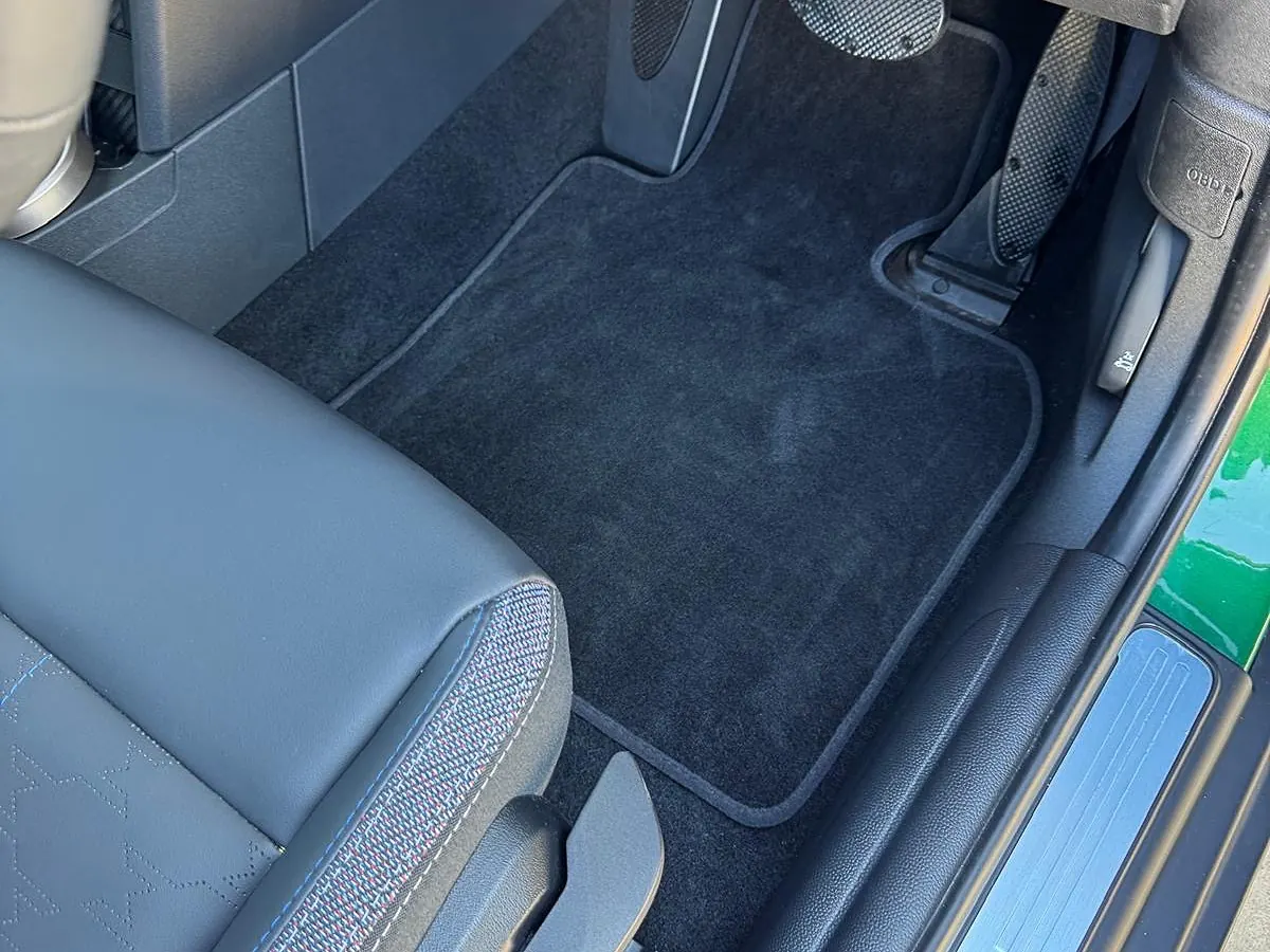 Front footwell carpet mat vacuumed with clean edges and sill