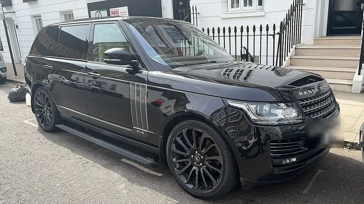 A black Range Rover gleaming at the kerb on a white stucco London street after a Mini Valet