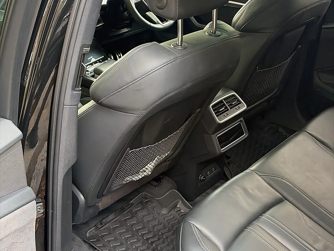 Rear cabin of a black SUV after a Mini Valet, leather seats wiped and rubber mats clean