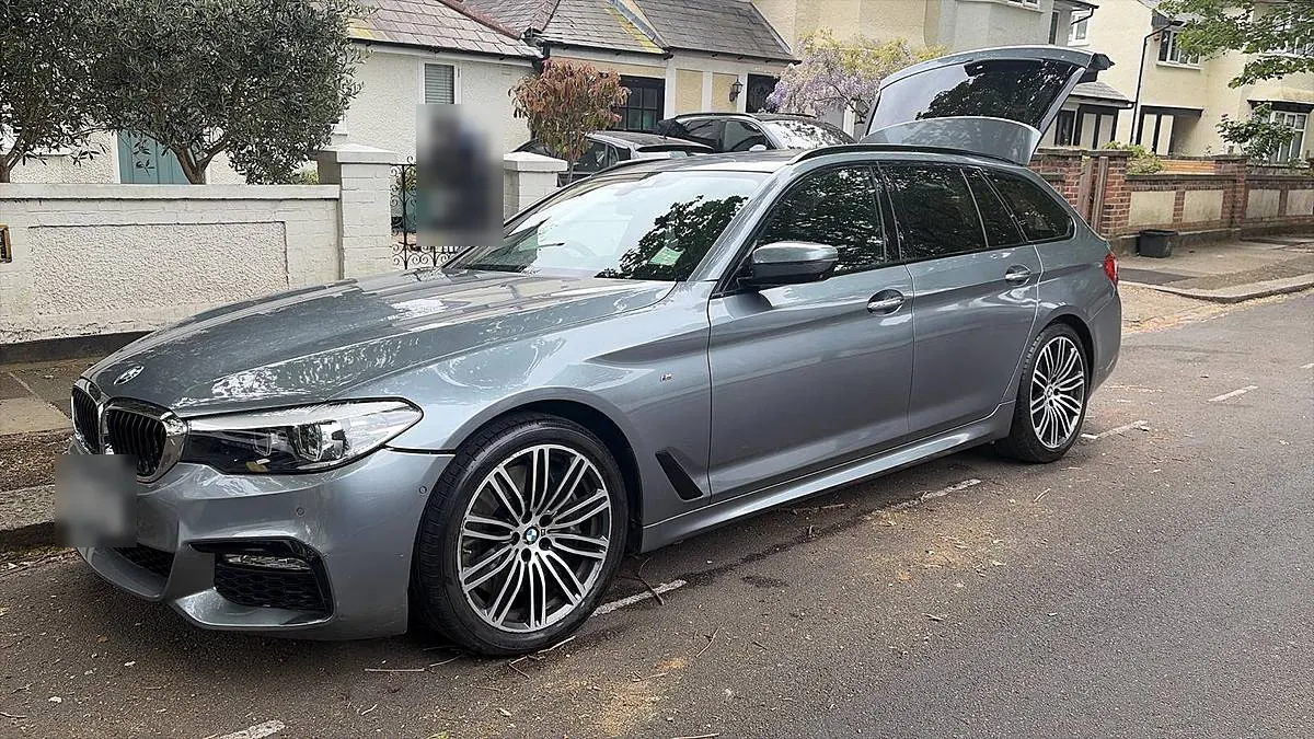 A grey BMW 5 Series Touring clean and shining on a residential London street
